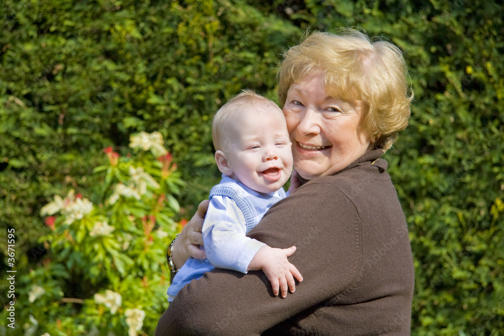 Grandmother hugging happy grandson in sunny garden Grandmother hugging happy grandson in sunny garden