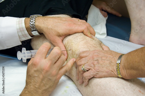 Doctor Giving Injection in the Knee of a Patient