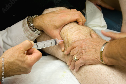 Doctor Giving Injection in the Knee of a Patient