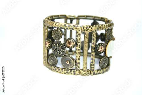Metallic ancient style bracelet with ornaments and stones.