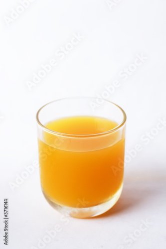 A glass of orange juice on a white background