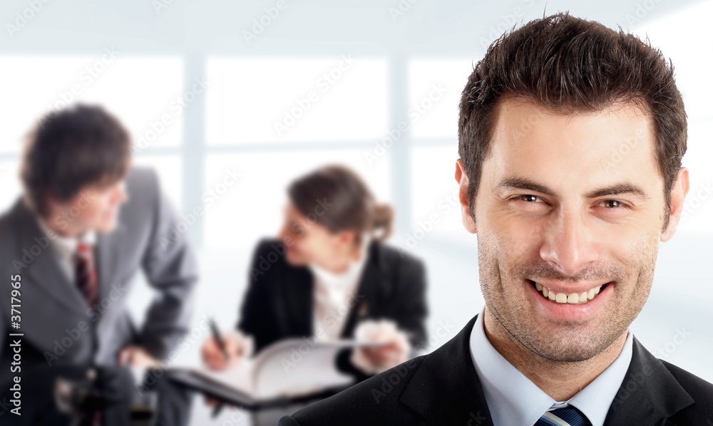 Handsome Businessman in front of his colleagues Handsome Businessman in front of his colleagues