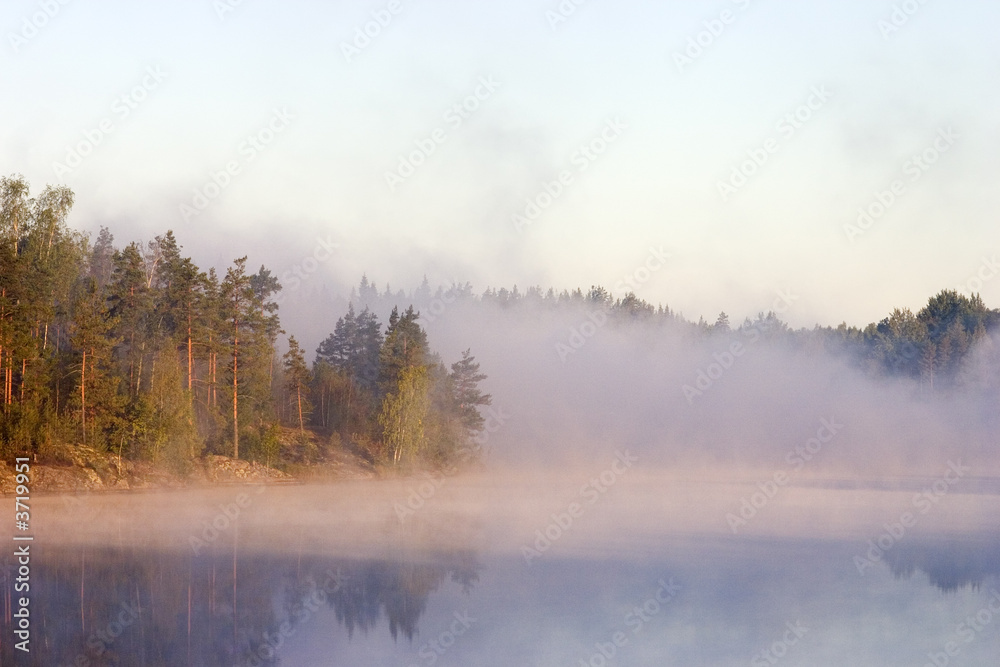 Fog at a dawn on lake in Kareliya