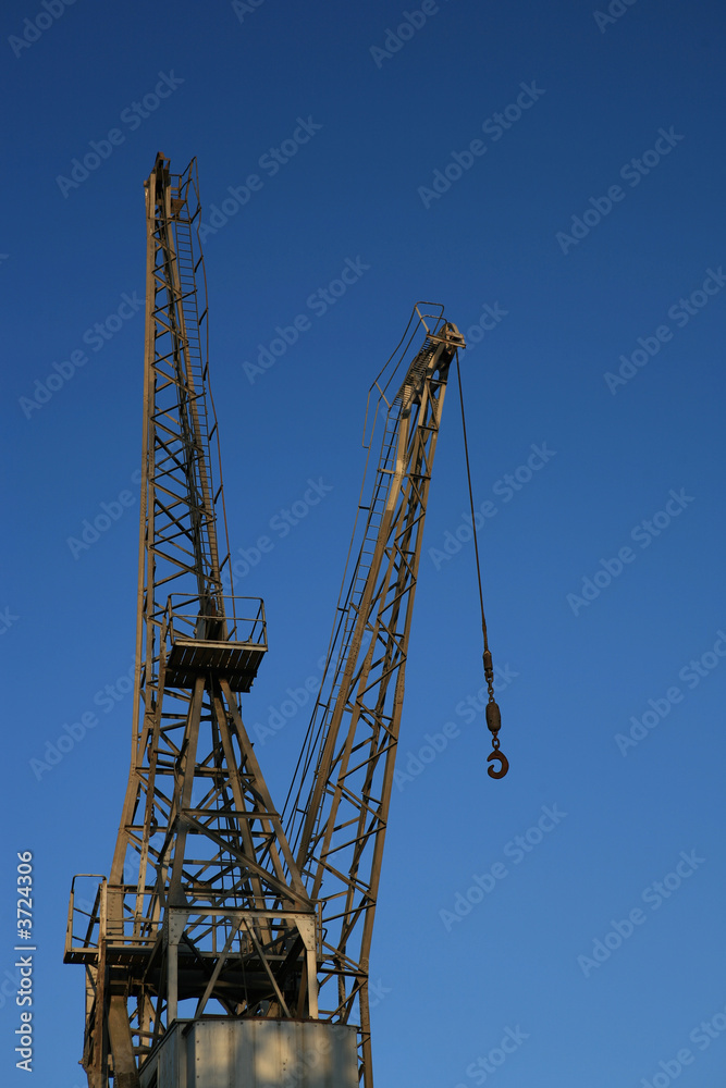 A dockside crane against a clear blue sky. A dockside crane against a clear blue sky.