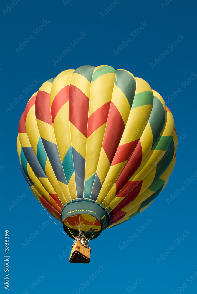 Fototapeta premium Colorful Hot Air Balloon ascending into a clear blue sky