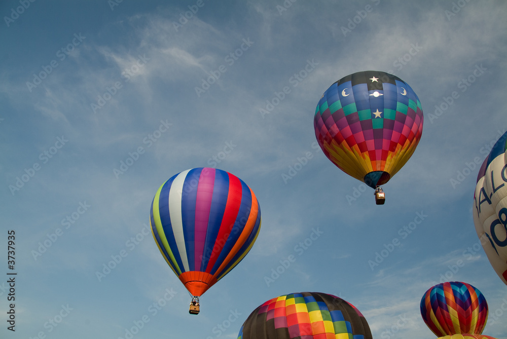 Ascending colorful hot air balloons into a blue sky Ascending colorful hot air balloons into a blue sky