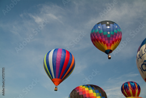 Ascending colorful hot air balloons into a blue sky