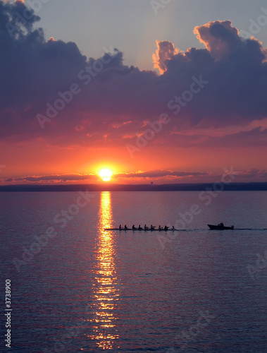 Crew practice on the lake at sunset