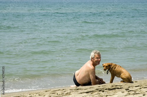 man with his dog on the beach photo