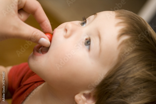 Adult feeding a candy to a baby