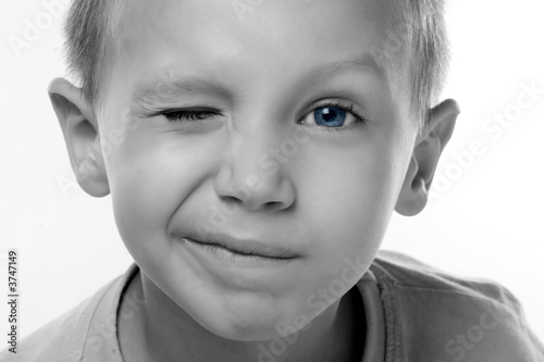 a boy with blue eyes is blinking
