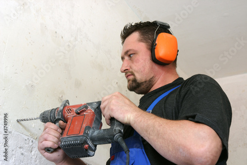 Worker with protective soundproofing ear muffs on. photo
