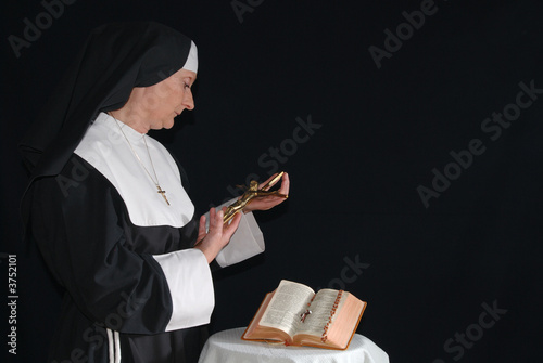 Middle aged devout nun in deep thoughts, praying.   photo