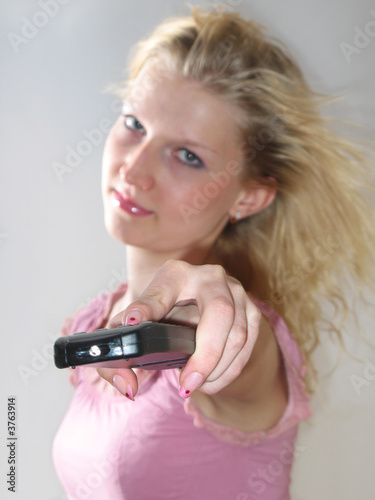 The TV Remote Control in girl's hand photo