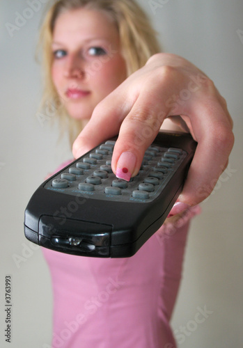 The TV Remote Control in girl's hand photo