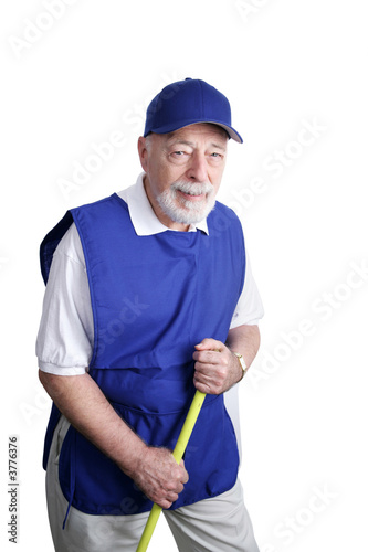 A senior man sweeping up at a discount store.