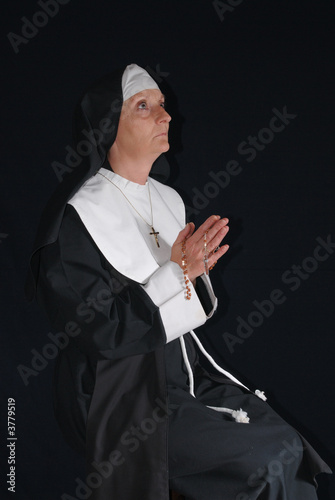 Middle aged devout nun in deep thoughts, praying. 