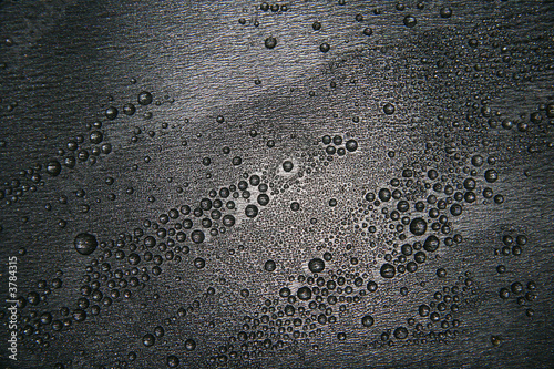 Small drops of water on a dark teflon surface. photo