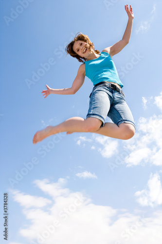 junges, schönes Mädchen springt unter dem Himmel