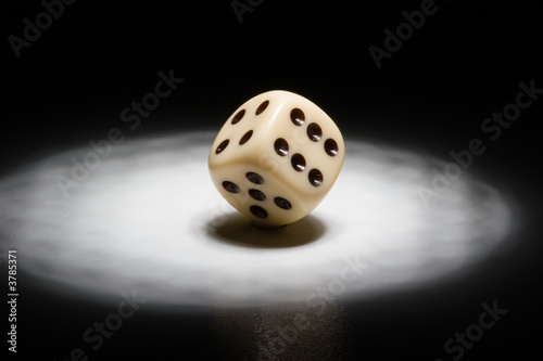 Tableau sur toile Dice in the spotlight - black background