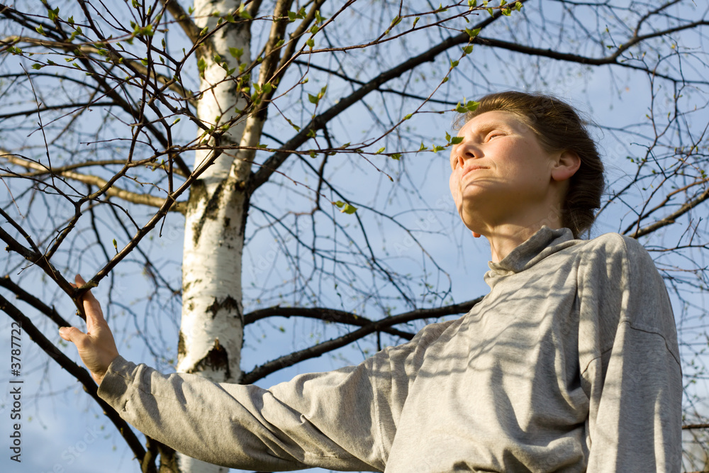 Woman and birch tree with leaves is expanding Woman and birch tree with leaves is expanding