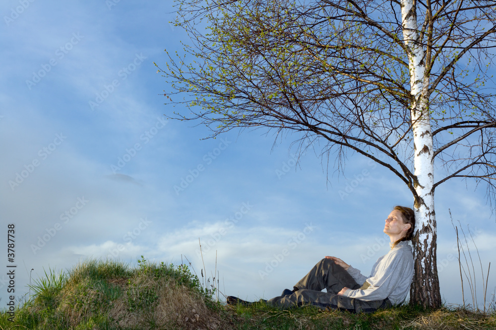 Woman under the birch at field