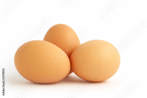 Three brown eggs, isolated on white.