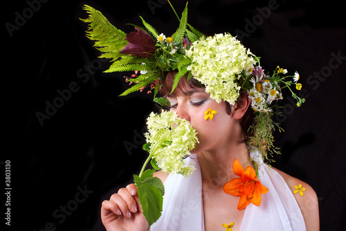 Obraz na plátně The young nice girl in a wreath from field flowers