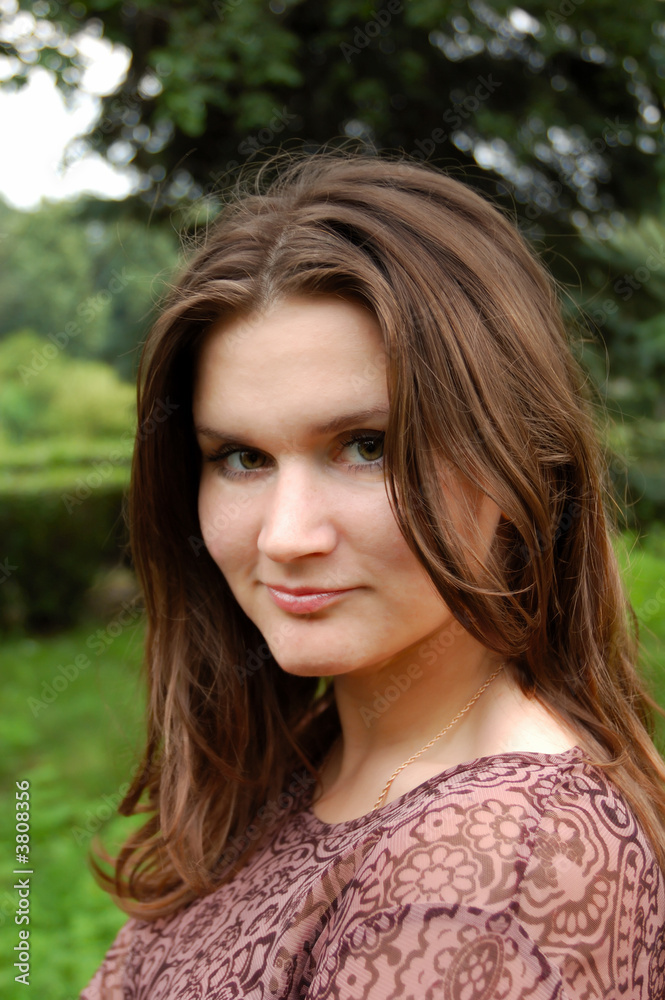 A beautiful young woman smiling at the park.