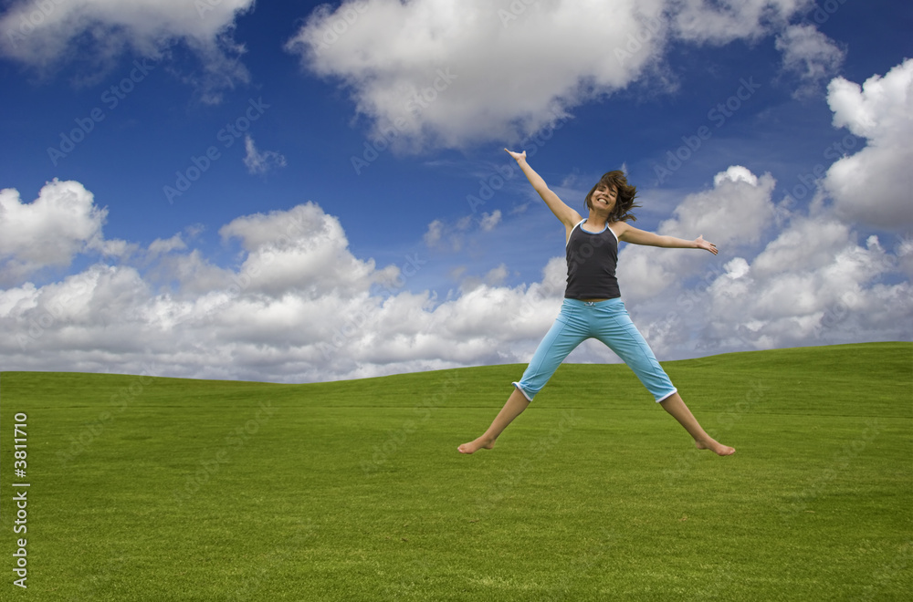 Beautiful happy woman jumping on a green field Beautiful happy woman jumping on a green field
