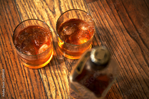 Fotografía Two glasses from whisky and a bottle on a wooden table