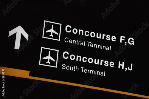 Airport sign showing direction to concourse and termi photo
