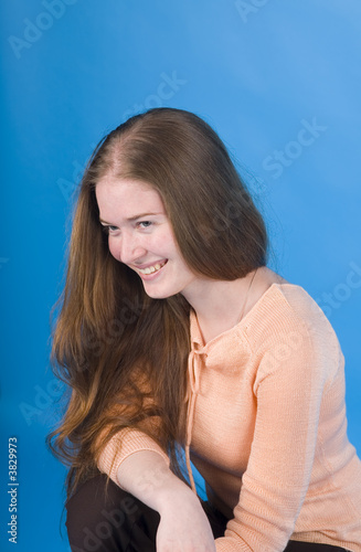 Portrait of the smiling girl on a blue background