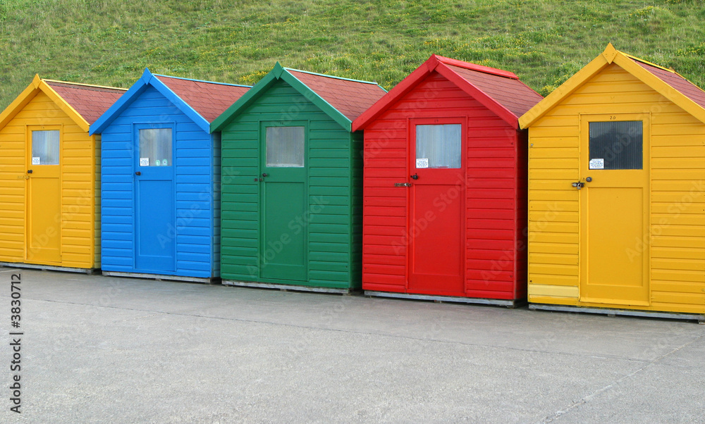 Five brightly coloured beach huts. Five brightly coloured beach huts.