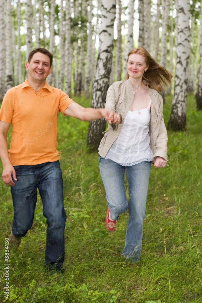two happy people running in the forest two happy people running in the forest