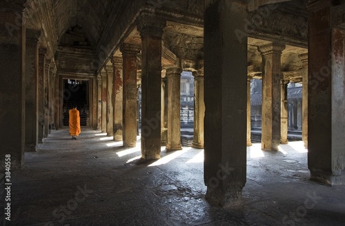 Angkor Wat interior, there is a monk walking on the corridor.