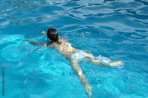 Active girl swimming in blue waters on pool