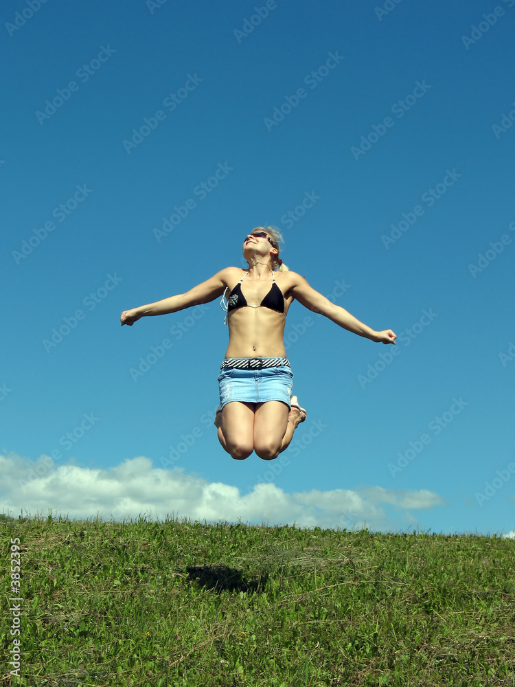Jumping girl on the grass and blue sky. Jumping girl on the grass and blue sky.