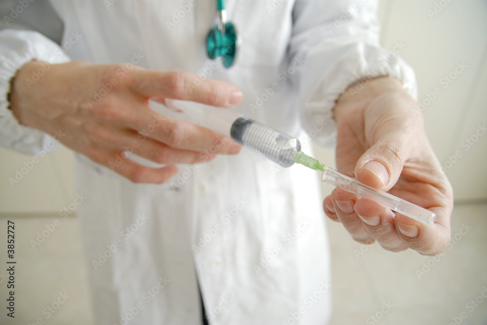 Docator holding with two hands a medical syringe Docator holding with two hands a medical syringe