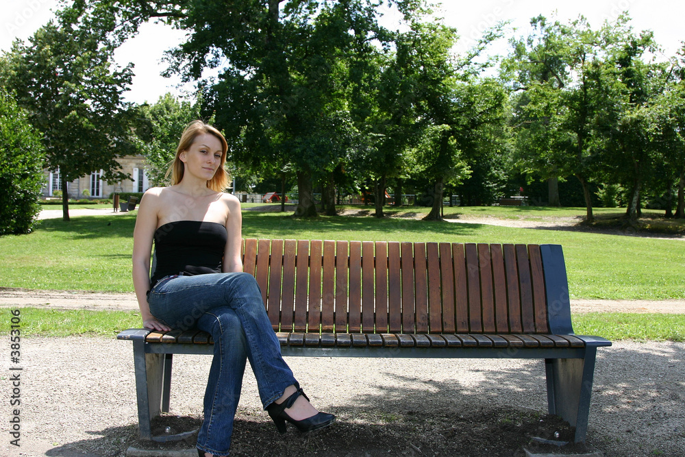 jeune femme blond assise sur un banc jeune femme blond assise sur un banc