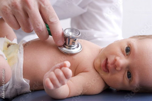 Close-up, high-key photo of a newborn baby getting examined