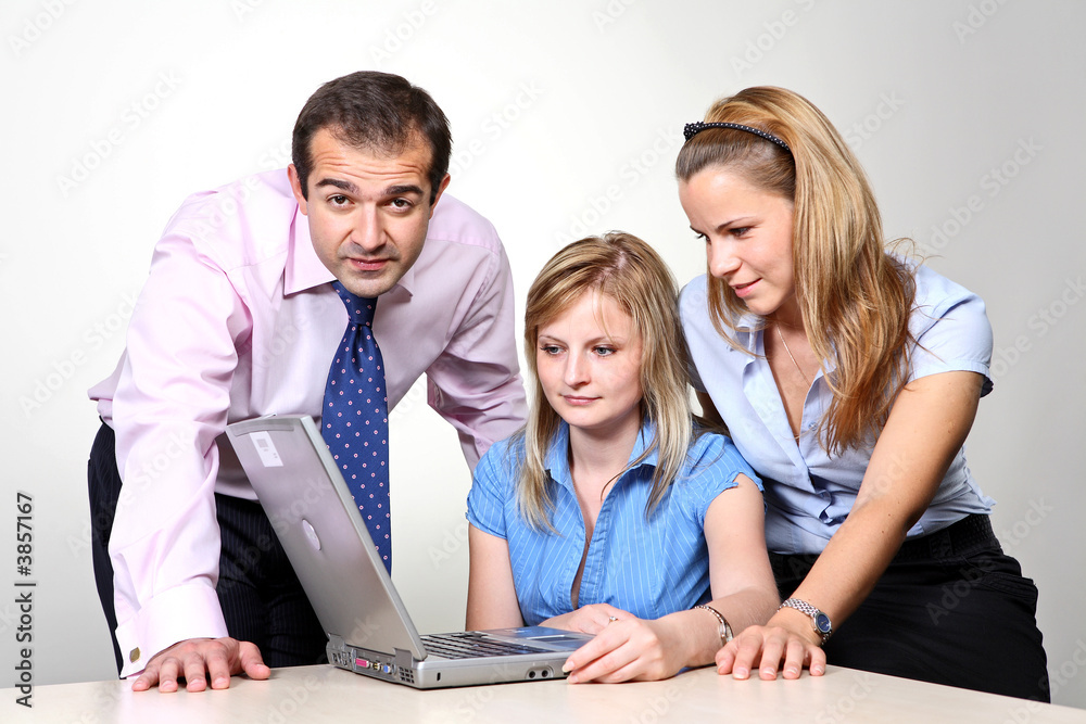 Three colleagues working at a computer.