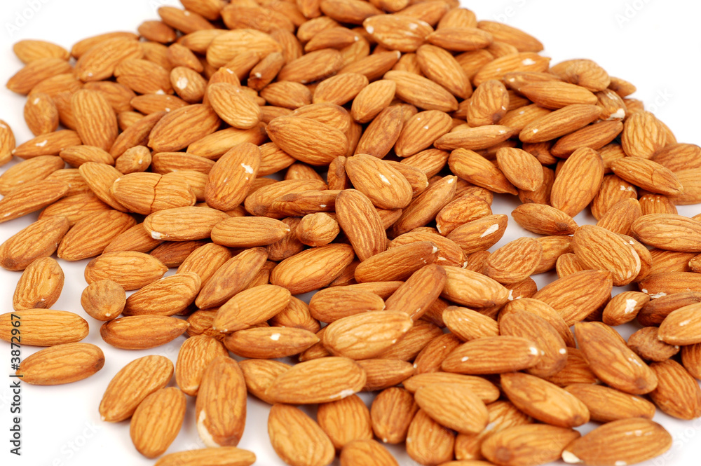 A group of shelled almond nuts on a white background. A group of shelled almond nuts on a white background.