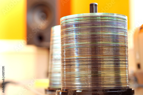 A spindle of CDs in an audio engineering studio.