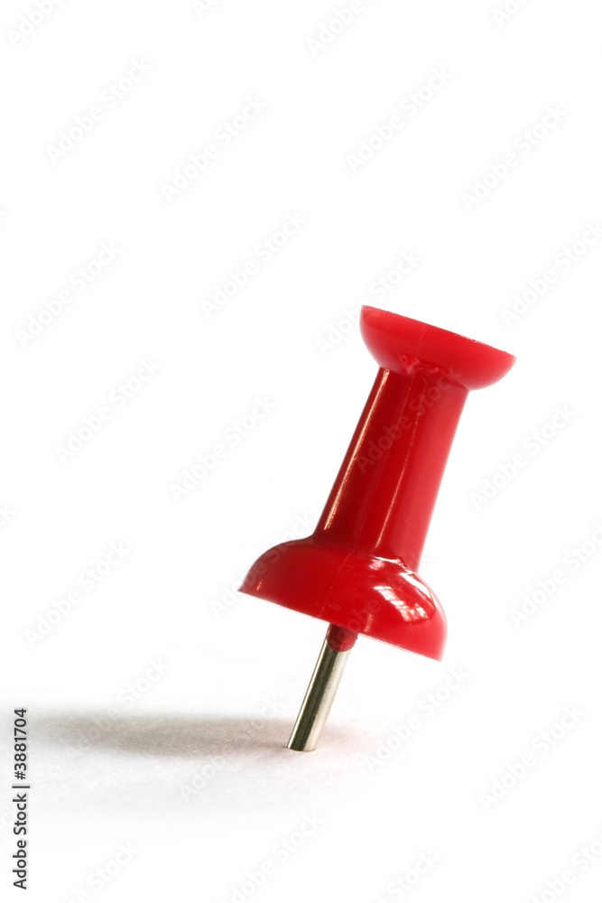 Red push pin casting shadow on white paper. Red push pin casting shadow on white paper.
