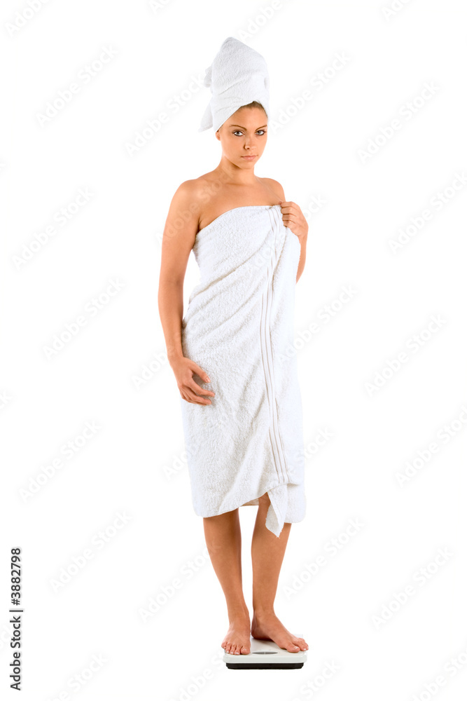 Beautiful Girl checking her weight wrapped in white bath towel Beautiful Girl checking her weight wrapped in white bath towel