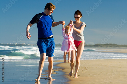 Young family carying the child on the beach
