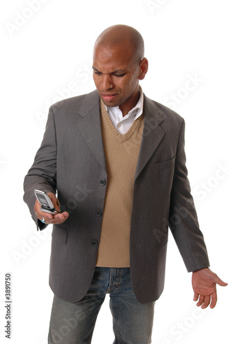 A businessman looking irately at his cell phone  photo