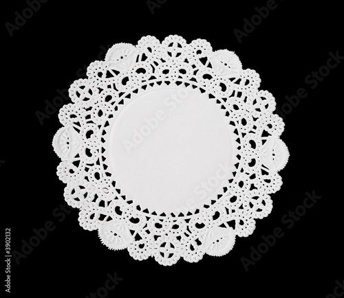 A decorative round doily isolated over black photo