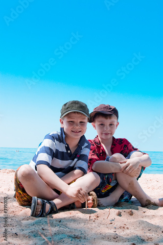 Two brothers sitting on the beach